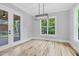 Bright dining area features hardwood floors, modern light fixture, and large windows with views to the outdoors at 5504 Earle Road, Raleigh, NC 27606