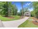 Beautiful two-story home nestled among mature trees, gray siding, and long driveway at 5504 Earle Road, Raleigh, NC 27606