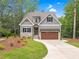 Charming home with stone accents, a well-manicured lawn, and a paved driveway at 5504 Earle Road, Raleigh, NC 27606