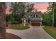 Charming home illuminated at sunset, featuring beautiful landscaping, and a paved driveway at 5504 Earle Road, Raleigh, NC 27606