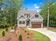 Charming home featuring a well-manicured lawn, beautiful landscaping, and a paved driveway at 5504 Earle Road, Raleigh, NC 27606