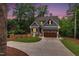 Charming two-story home with gray siding, stone accents, illuminated at dusk at 5504 Earle Road, Raleigh, NC 27606