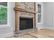 Close-up of the stone fireplace with a wooden mantel and hearth, adding rustic charm to the space at 5504 Earle Road, Raleigh, NC 27606