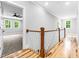 Hallway featuring wood floors and decorative railing, with an open view into a room at 5504 Earle Road, Raleigh, NC 27606