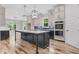 Modern kitchen featuring a large island with marble countertop, custom cabinets, and pendant lighting at 5504 Earle Road, Raleigh, NC 27606