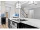 Open concept kitchen with oversized island, stainless steel appliances, modern lighting, and staircase access at 5504 Earle Road, Raleigh, NC 27606