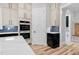 Modern kitchen with built-in ovens, custom cabinetry, tile backsplash, and pantry access at 5504 Earle Road, Raleigh, NC 27606