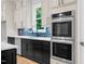 Bright kitchen featuring white and black cabinetry, stainless steel appliances, quartz counters, and a modern design at 5504 Earle Road, Raleigh, NC 27606