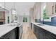 Open kitchen with island, stainless steel appliances, hardwood floors, custom cabinetry, and access to dining area at 5504 Earle Road, Raleigh, NC 27606