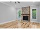 Bright living room featuring hardwood floors and a stone fireplace, creating a cozy and inviting atmosphere at 5504 Earle Road, Raleigh, NC 27606