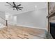 Open living room with wood floors, fireplace, and modern ceiling fan at 5504 Earle Road, Raleigh, NC 27606