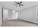 Serene primary bedroom with carpet, tray ceiling, ceiling fan, and doorways to en-suite bathroom and closets at 5504 Earle Road, Raleigh, NC 27606