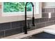 Modern kitchen sink and faucet with a window view, accompanied by subway tile backsplash and bright countertops at 5504 Earle Road, Raleigh, NC 27606