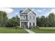 Charming two-story home featuring stone accents, gray siding, and lush landscaping, creating inviting curb appeal at 5545 Cayden Cove Dr, Wendell, NC 27591