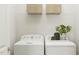 Bright laundry room with front-load machines and decorative storage baskets at 5545 Cayden Cove Dr, Wendell, NC 27591