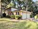 Backyard view of the home showcasing a garage, brick exterior, and established landscaping at 5617 Partridge Ln, Raleigh, NC 27609