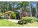 Backyard of a brick house, including a brick patio, wooden deck, and large trees at 5617 Partridge Ln, Raleigh, NC 27609