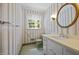 Charming bathroom featuring striped wallpaper, vanity with sink, and a window at 5617 Partridge Ln, Raleigh, NC 27609