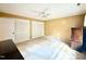 Bright bedroom featuring tan walls, a ceiling fan, carpet floors, and multiple closet doors at 5617 Partridge Ln, Raleigh, NC 27609