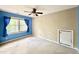Bedroom with blue walls, ceiling fan, carpet floors, window with blue curtains, and plaid wall paper at 5617 Partridge Ln, Raleigh, NC 27609