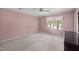 This light pink bedroom features an overhead fan and bright window at 5617 Partridge Ln, Raleigh, NC 27609