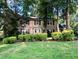 Charming brick home with a manicured lawn and mature trees providing shade at 5617 Partridge Ln, Raleigh, NC 27609