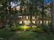 Charming two-story brick home with black shutters, lush landscaping, and mature trees at 5617 Partridge Ln, Raleigh, NC 27609