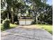 Driveway view of a garage with brick details surrounded by lots of trees at 5617 Partridge Ln, Raleigh, NC 27609