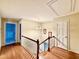 Upstairs hallway featuring hardwood floors, a chandelier, and various doorways at 5617 Partridge Ln, Raleigh, NC 27609