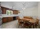 Kitchen with tile floors, wooden cabinetry, an adjacent wooden table, and natural lighting at 5617 Partridge Ln, Raleigh, NC 27609