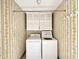 Laundry room with floral wall paper and white dryer and washing machine at 5617 Partridge Ln, Raleigh, NC 27609
