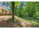 Landscaped backyard with mature trees and privacy fence at 5709 Russell Rd, Durham, NC 27712