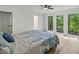 Bedroom with ceiling fan, view of trees, and lots of natural light from large windows at 5709 Russell Rd, Durham, NC 27712