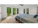 Bright bedroom with a ceiling fan and large windows providing lots of natural light and view of the trees at 5709 Russell Rd, Durham, NC 27712
