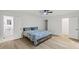 Spacious bedroom with hardwood floors, a ceiling fan, and a door leading to a bathroom at 5709 Russell Rd, Durham, NC 27712