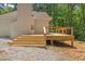 Modern deck with wooden railings, steps, and gravel surroundings at 5709 Russell Rd, Durham, NC 27712