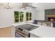Modern kitchen with stainless appliances, island cooktop, and views of the backyard patio at 5709 Russell Rd, Durham, NC 27712