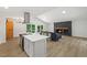Open-concept living room with a stone fireplace, island, and sliding glass doors to the deck at 5709 Russell Rd, Durham, NC 27712