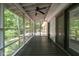 Charming screened porch with ceiling fan, offering a view of the surrounding greenery at 5709 Russell Rd, Durham, NC 27712
