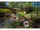 Front exterior view of stone home with beautiful flower garden leading to the home's front entrance at 5836 Sandstone Dr, Durham, NC 27713