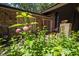Charming stone and wood exterior showcasing landscaped flower garden leading up to the front door at 5836 Sandstone Dr, Durham, NC 27713