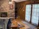 Cozy living room with a stone fireplace, wood-paneled walls, and access to the outside at 5836 Sandstone Dr, Durham, NC 27713