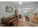 Bright living room with wood floors featuring a piano and large windows providing abundant natural light at 5836 Sandstone Dr, Durham, NC 27713