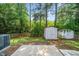Backyard with a concrete patio and storage sheds, offering both relaxation space and practical storage solutions at 6008 River Lake Cir, Raleigh, NC 27604