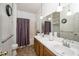 Bathroom features a double sink vanity, ample lighting, and a shower-tub combination with a patterned shower curtain at 6008 River Lake Cir, Raleigh, NC 27604