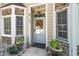 Close-up of the front door with decorative wreath and well-kept potted plants enhancing the entrance at 6008 River Lake Cir, Raleigh, NC 27604