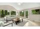 Living room with vaulted ceilings surrounded by windows and a doorway leading to an outdoor area at 623 Totten Pl, Chapel Hill, NC 27514