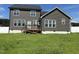 Rear view of a two-story home with gray siding, white trim, and a wooden deck overlooking a spacious backyard at 644 Wall Rd, Wendell, NC 27591