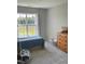 Bedroom with a large window, gray walls, and neutral carpet offering natural light and serene atmosphere at 644 Wall Rd, Wendell, NC 27591