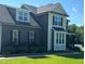 Two-story home with dark siding, gray shingled roof, green grass, and landscaping at 644 Wall Rd, Wendell, NC 27591